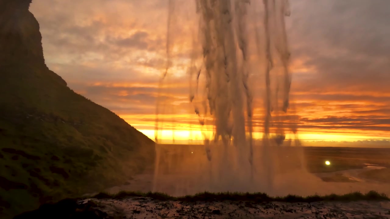 Panorámica de Seljalandsfoss mientras el agua que cae capta la luz del atardecer en cámara lenta