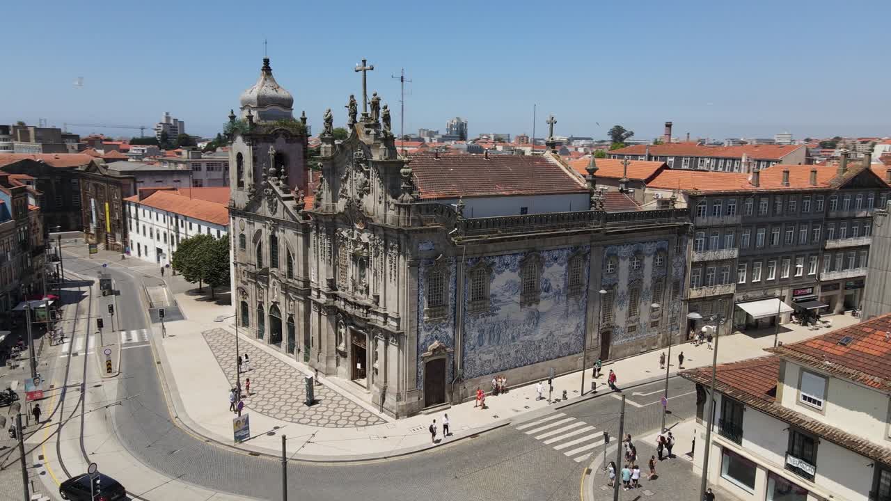 Vista aerea con drone di una storica chiesa barocca con facciata dettagliata a Viana do Castelo, Portogallo. Strade cittadine, tetti in tegole e skyline costiero appaiono sotto un cielo azzurro e limpido in piena luce diurna.