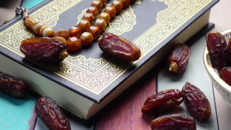 holy book quran and rosary on table, close up.