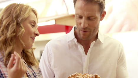 young happy couple looking at cakes