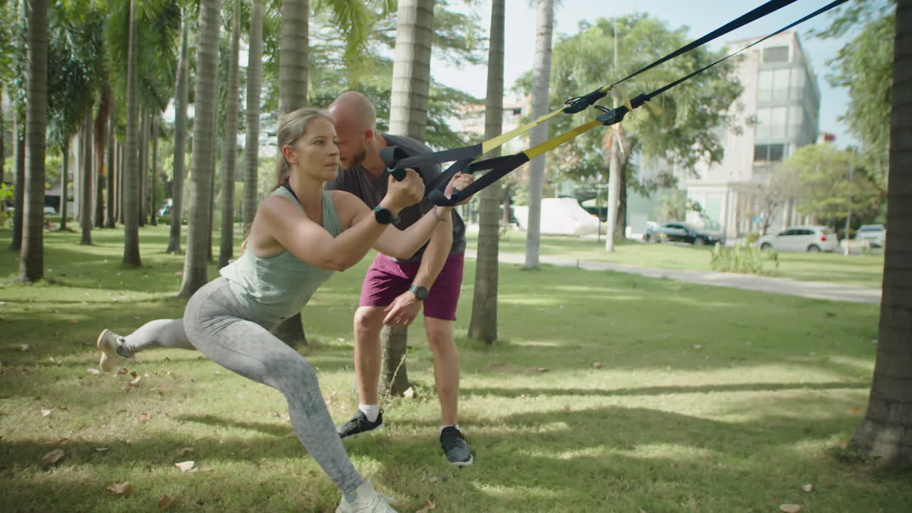 Woman Having Suspension Workout with Help of Personal Trainer