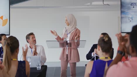 female speaker and applauding audience at a business conference