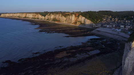 revealing shot of french village at the steep shores of the french normandy atlantic ocean at sunset