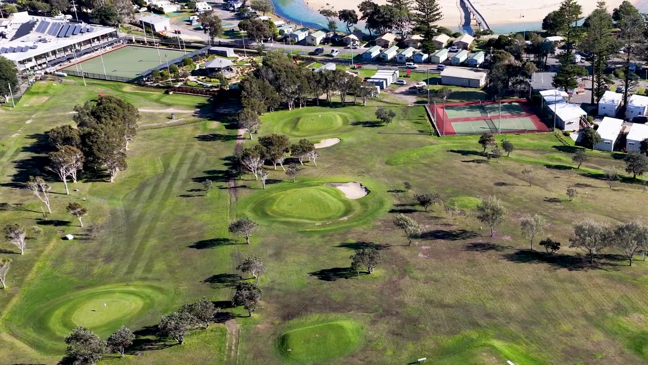 Ripresa aerea con drone di un lussureggiante campo da golf e strutture sportive a Crescent Head, Australia.