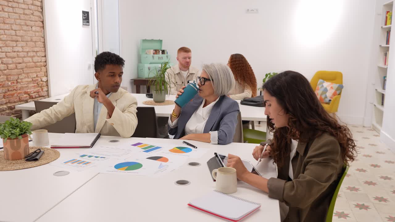 Diverse Business Team Collaborating on Project in Modern Office