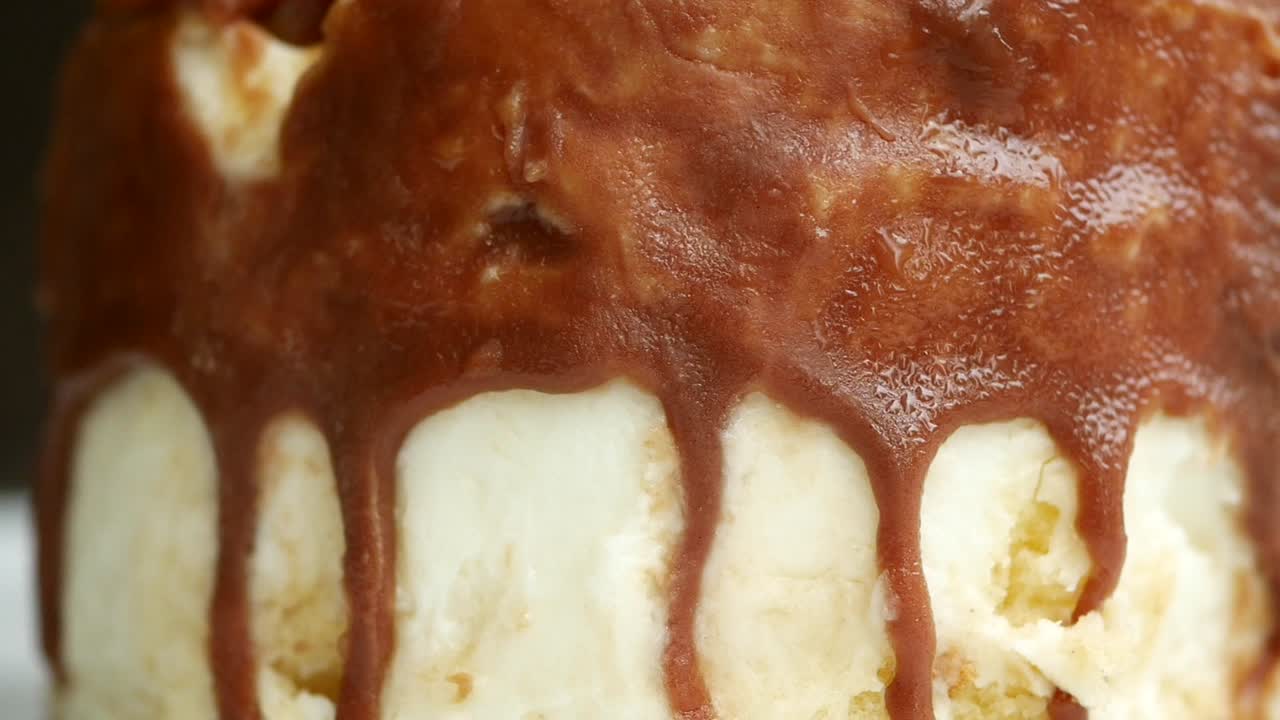 primer plano de helado de vainilla con salsa de chocolate que gotea