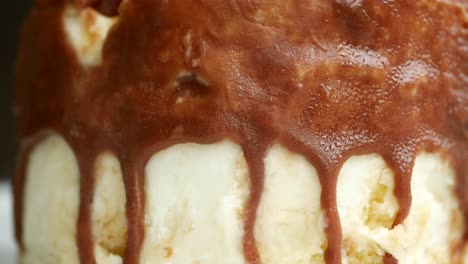 close-up of vanilla ice cream with dripping chocolate sauce