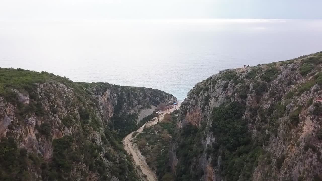 Desfiladeiro de Gjipe com vista para a praia de Gjipe, com o Mar Adriático ao fundo e o pôr do sol