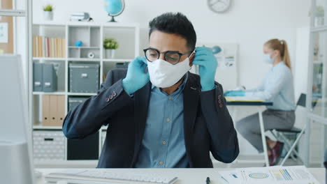business people wearing masks and gloves in the office during a pandemic