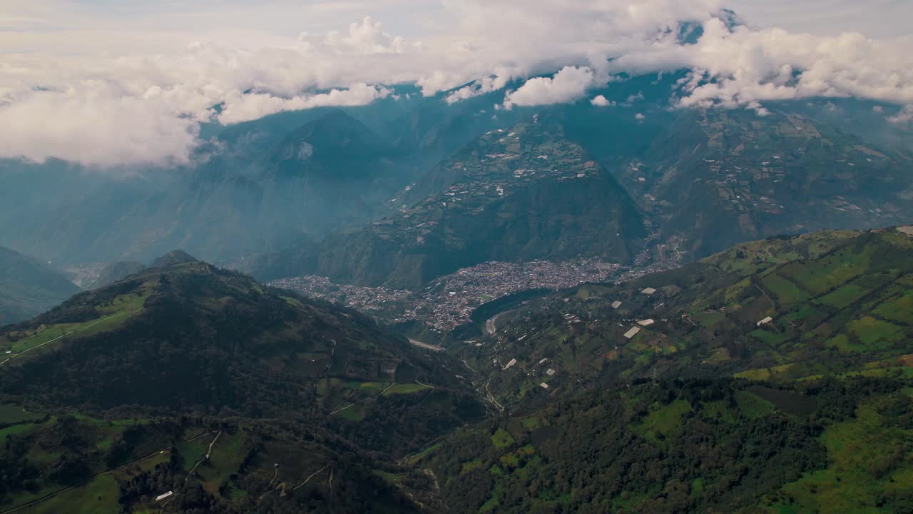 Misty cloud inversions, lush valleys, rugged Andean slopes, and the town nestled below. Ideal for travel, nature, and adventure content