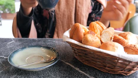 mujer disfrutando de café y pan en una cafetería