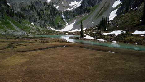 Flying-low-above-turquoise-crystal-clear-alpine-creek,-aerial-shot,-West-Kootenays