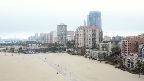 4k-Drohne-Umkreist-Lange-Strandstadtgebäude-Und-Sand