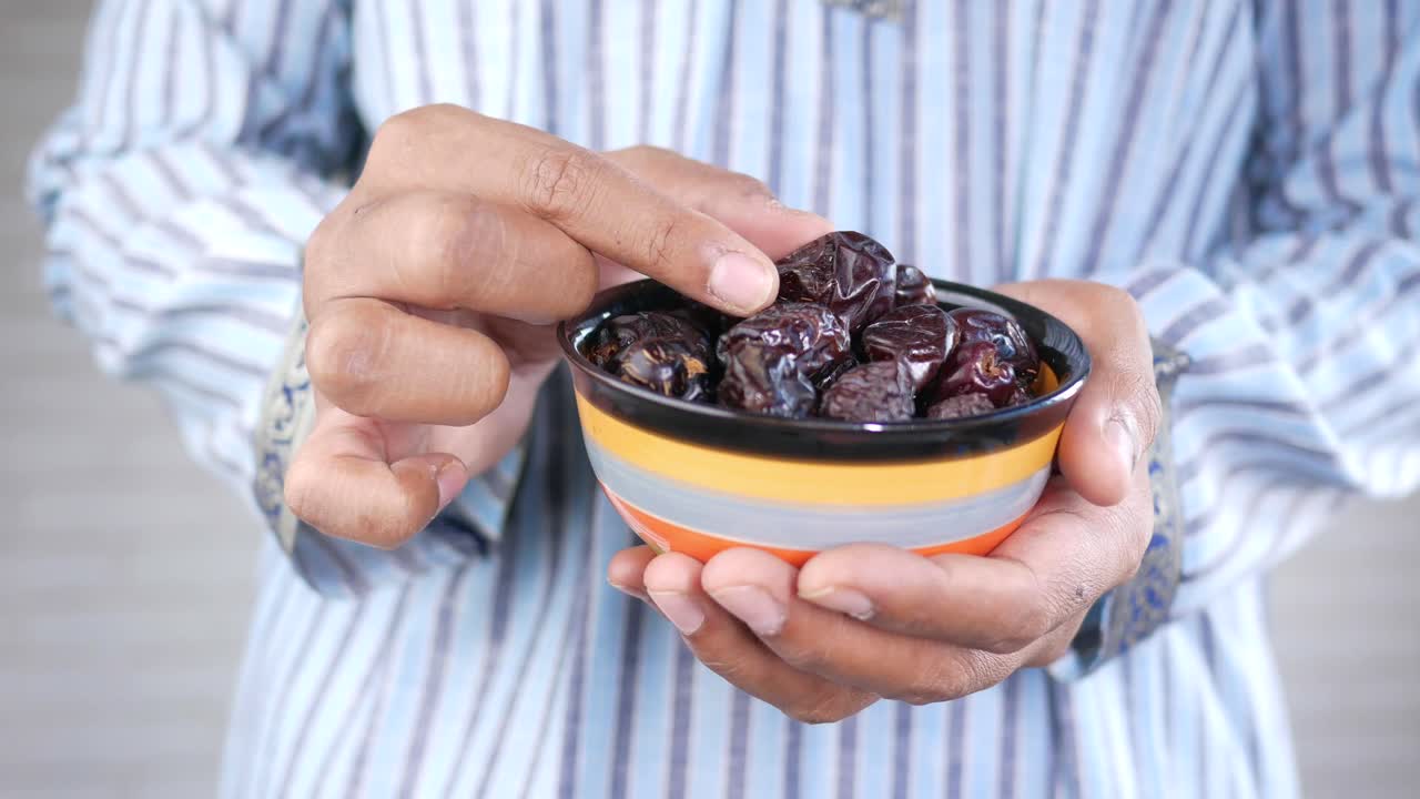 Person holding a bowl of dates