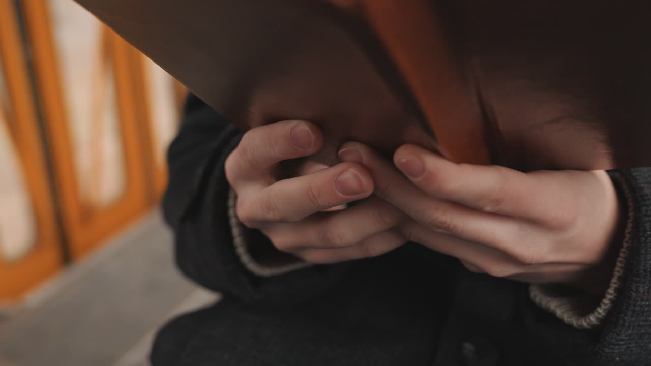 White creator closeup hands examining binding, leather cover and visible stitches, gentle thumb motion flipping pages, tactile paper texture and grain, artisan study vibe on vintage tram, focus