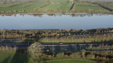 irish motorway parallels calm reflective river suir in green waterford