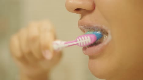 pregnant woman brushing teeth in the bathroom