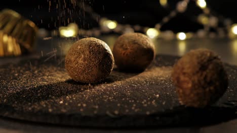 cámara lenta de azúcar dorada cayendo sobre trufas de chocolate