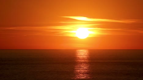 hermoso sol detrás de dramáticas nubes naranjas en el cielo del atardecer sobre el océano