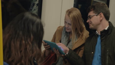 subway passengers using tablet pc