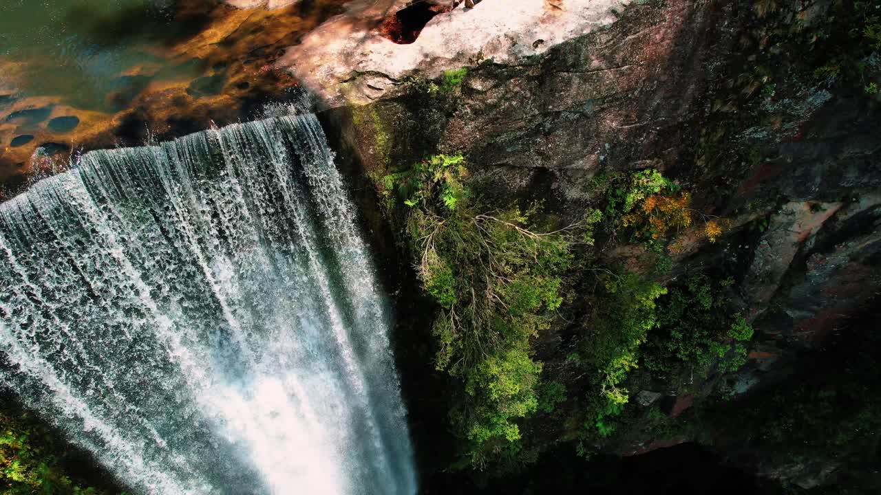 cataratas de belmore, australia, drones bajan por la cascada, revelando una pareja en la cima