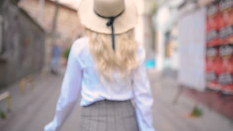 attractive young beautiful girl with hat walks and discovers places in narrow street