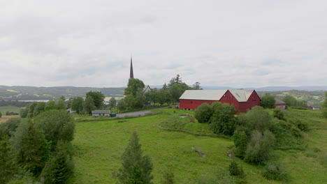 hill farm and church tower in rural scandinavian landscape at spring