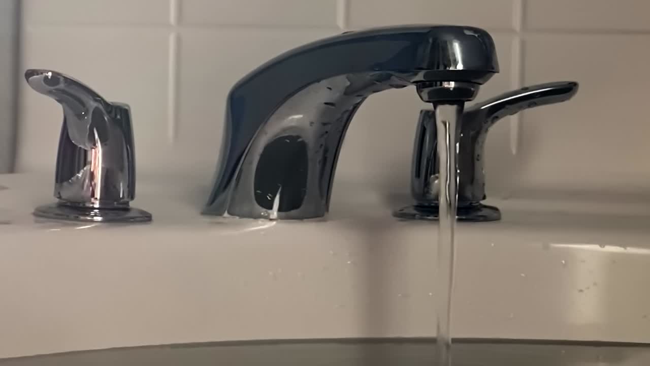 Running water for a bath out of tap into bath tub, slow motion closeup