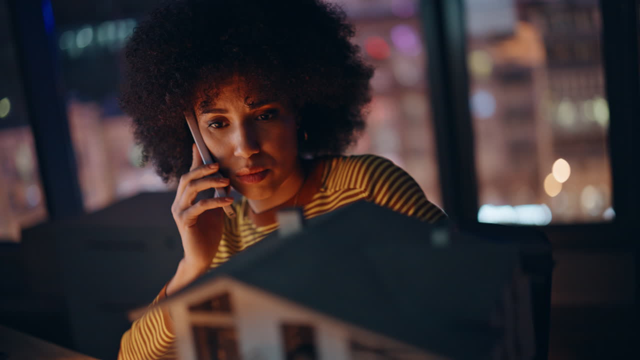 Night manager speaking cellphone discussing house layout mistake closeup