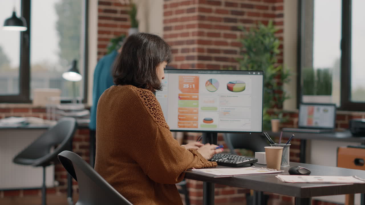 A woman works at a computer in an office setting