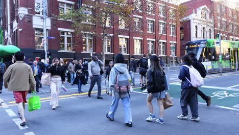 pedestrians crossing a busy street in melbourne