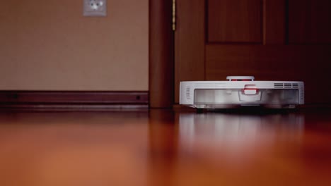 robot aspirador inteligente con lidar en el suelo de madera. robot aspirador realiza la limpieza automática del apartamento. 4k cámara lenta 100 fps, prores 422, 10 bits