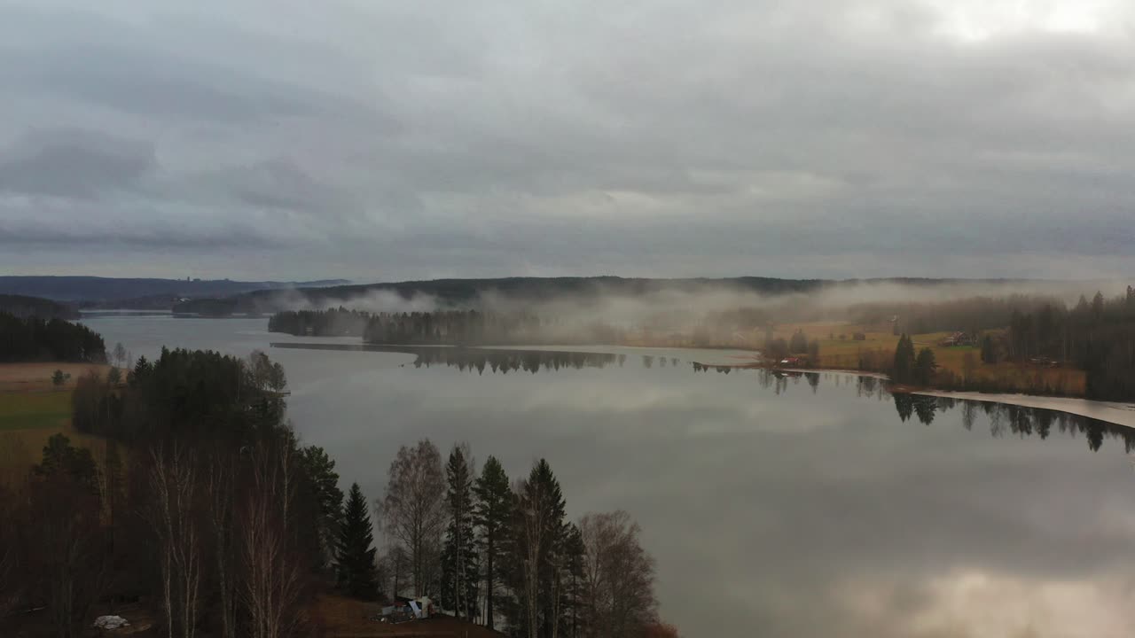 Orbit shot revealing a lake covered in mist in Sweden