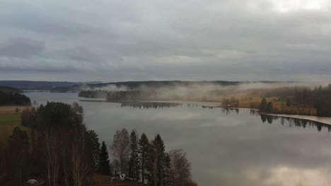 orbit shot revealing a lake covered in mist in sweden