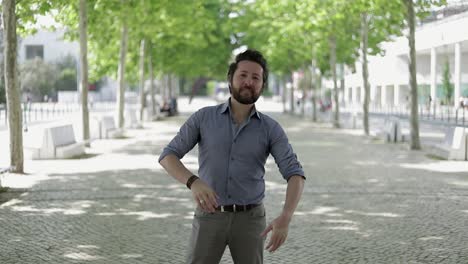 cheerful bearded man posing on street