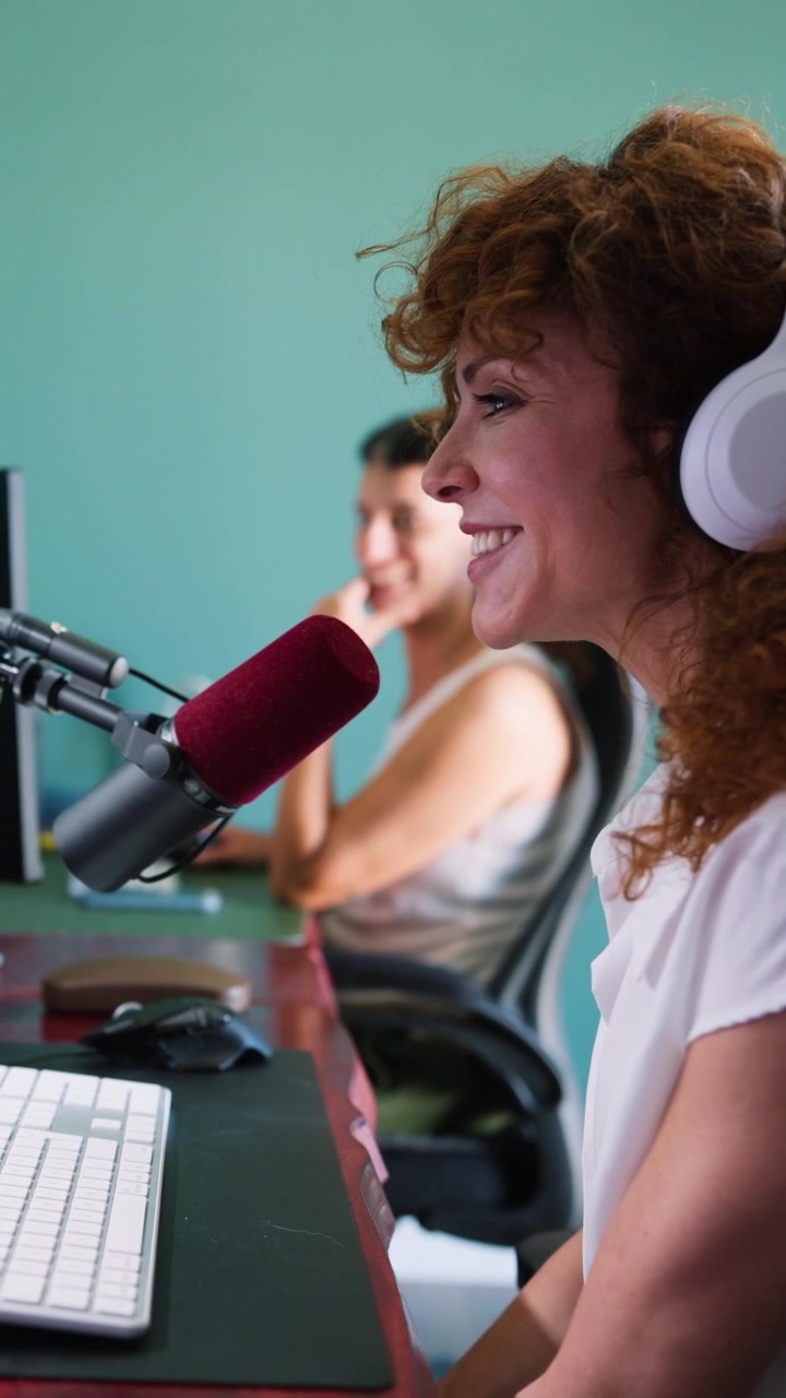 Donna che registra un podcast in studio con un collega.