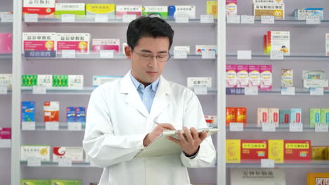 Druggist-Portrait-of-intelligent-focused-man-woman-checking-online-list-of-medications-comparing-stock-on-shelves-in-drugstore