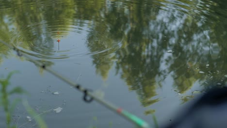 closeup circle trail on water pond smooth surface during tossing fishing rod with float