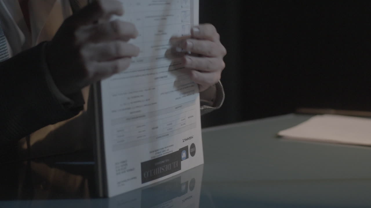 Person Working at a Desk with Documents and Tablet