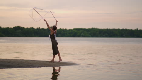 Una-Joven-Hippie-Vestida-Y-Con-Plumas-En-La-Cabeza-Hace-Enormes-Burbujas-De-Jabón-Al-Atardecer-En-La-Orilla-De-Un-Lago-En-Cámara-Lenta