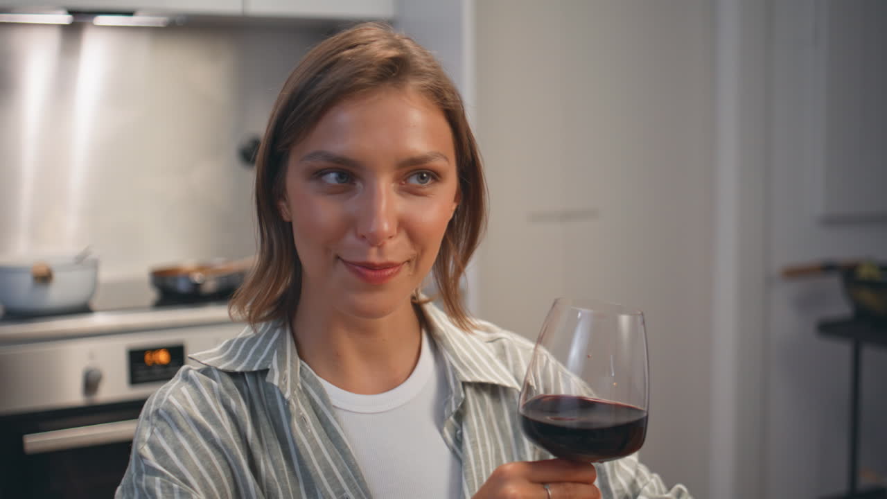 Smiling woman enjoy dinner in cozy kitchen closeup. Wife clinking wine glasses