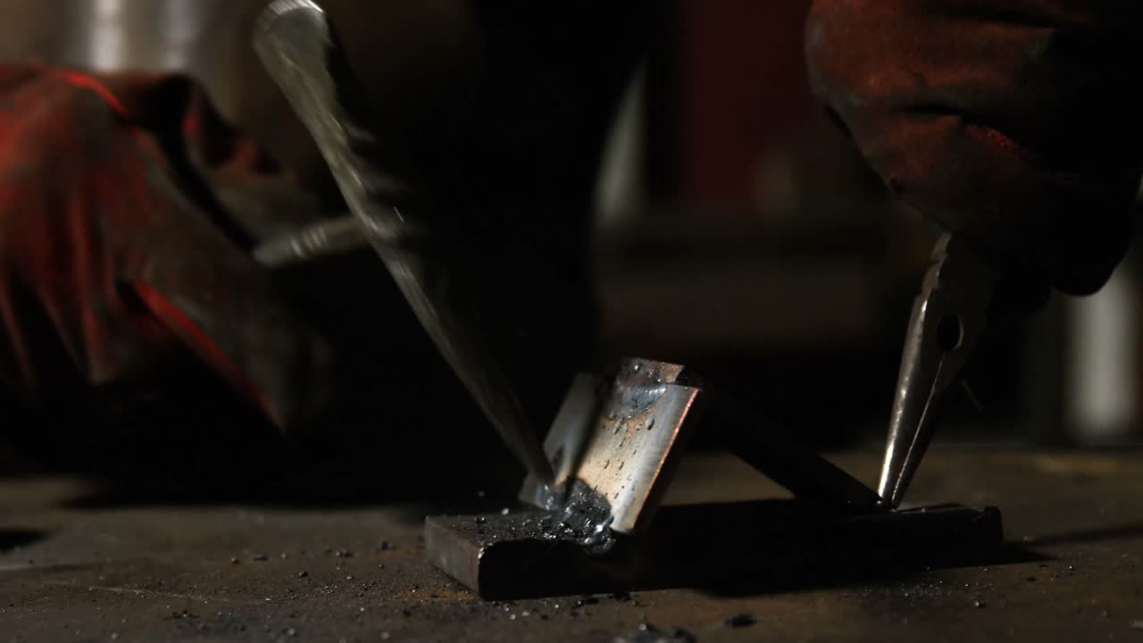 Hands of welder working on a piece of metal