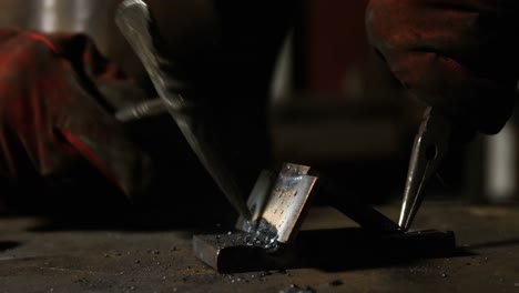 Hands-of-welder-working-on-a-piece-of-metal