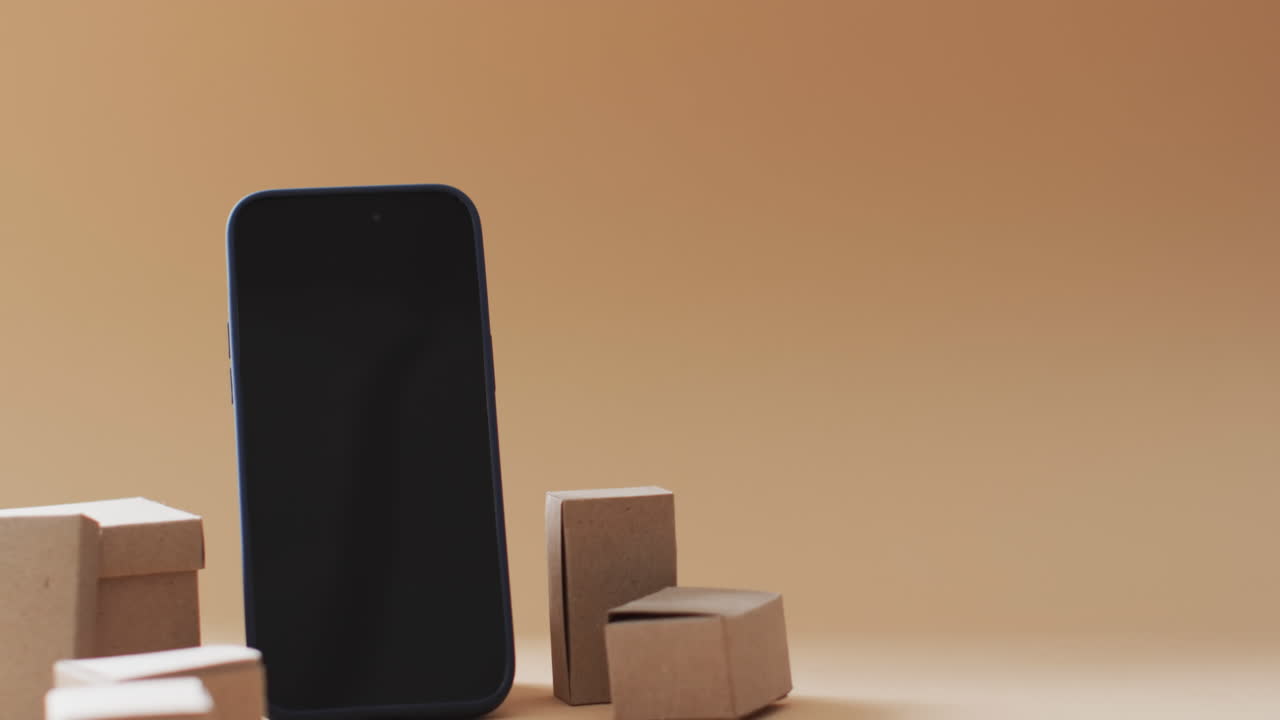 오렌지색 배경에 빈 화면과 복사 공간이 있는 상자의 스마트폰 비디오