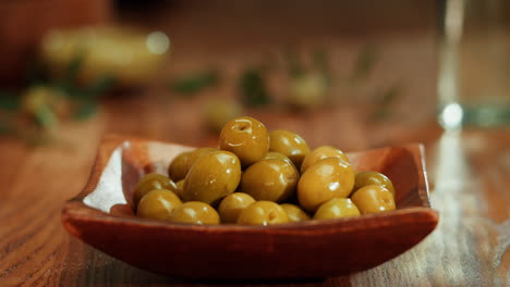 hand picking a green olive from a bowl