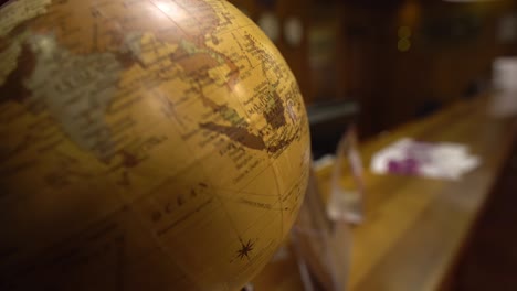 old vintage spinning globe model on map background. selective focus.