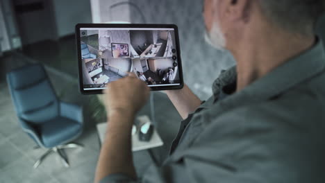 hombre usando tableta para monitorear cámaras de seguridad