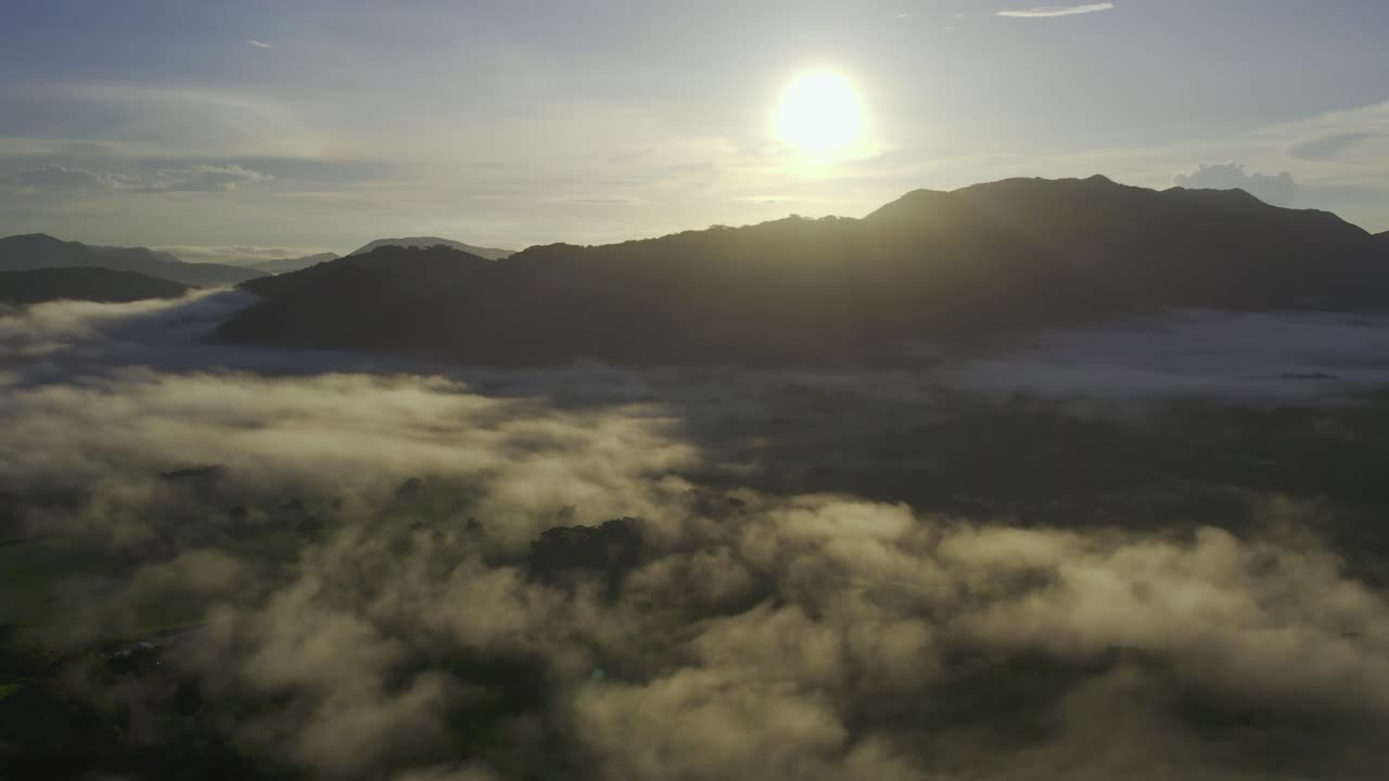puesta de sol brillante sobre la montaña de la sombra con nubes sobre la selva de costa rica, dron 4k
