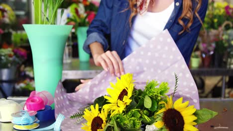 Female-florist-preparing-flower-bouquet