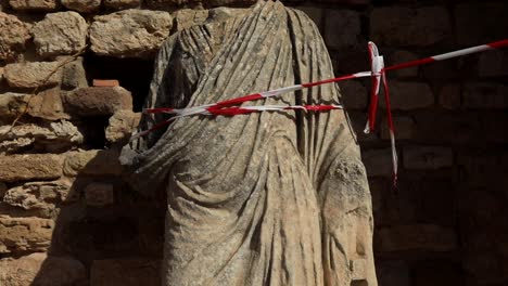 Ancient-Roman-statue-fragment-in-Carthage-ruins,-Tunisia,-with-warm-sunlight